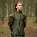 Man wearing MFH Brand U.S. Military style flecktarn camo combat tactical field shirt in forest setting