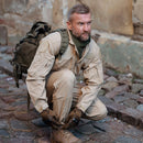 Man wearing tactical gear and Original Austria military backpack in olive green on cobblestone street