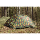Belgian military two-person waterproof ripstop tent set up in a forest with camouflage pattern and stakes secured.