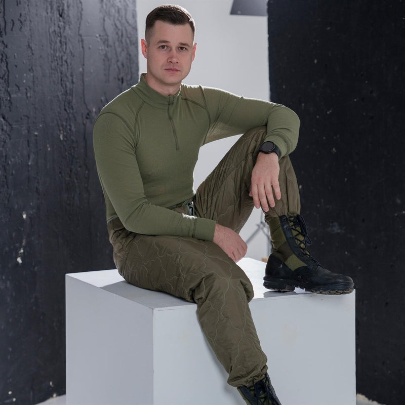 Man wearing genuine Dutch military thermal underwear shirt with high neck and long sleeves sitting on white block