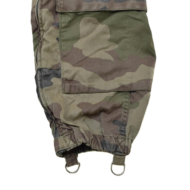 Close-up of genuine French military CCE camouflage coverall pant leg with reinforced stitching and metal loops