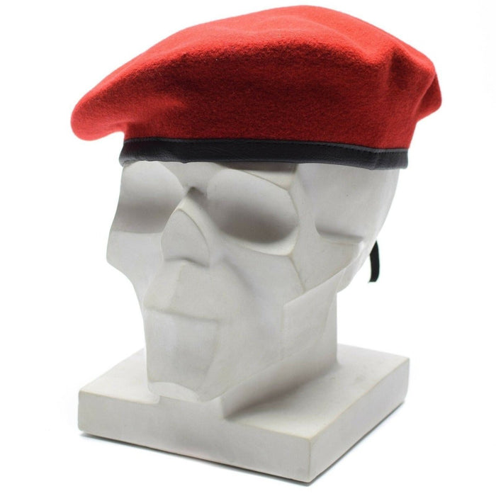 Véritable béret en laine rouge corail de l'armée allemande avec lanière en cuir réglable affiché sur une tête de mannequin tête de mort blanche.