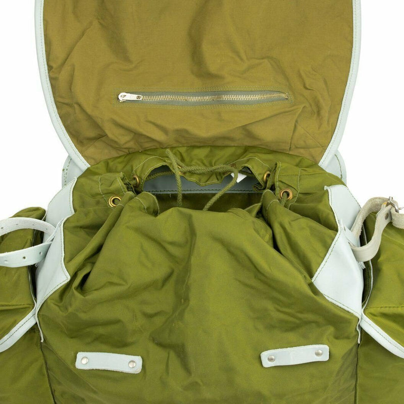 Open vintage Norwegian military green canvas backpack with metal frame and leather straps, showing interior and zippered pocket