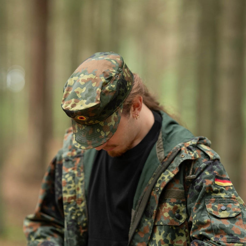Man wearing genuine German army Flecktarn cap and jacket in BW woodland camo pattern in forest setting