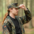 Man wearing genuine original German army Flecktarn cap and camouflage jacket in woodland forest setting