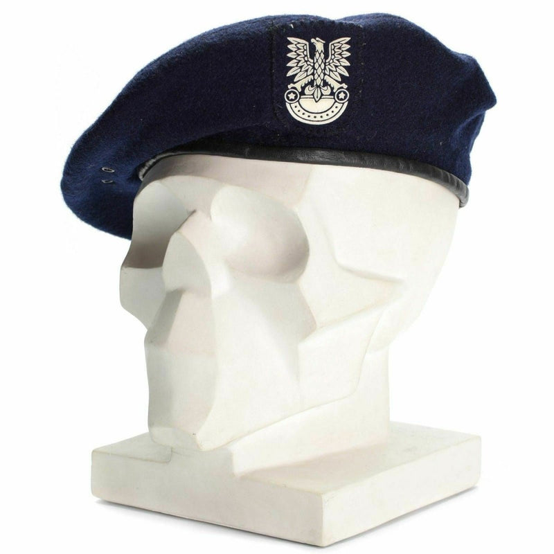Genuine Polish military blue beret with emblem on white mannequin head, symbolizing honor and service
