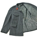 Grey Swiss military surplus wool jacket with chest pockets and red insignia on collar, featuring a satin-lined interior.