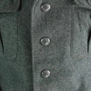 Close-up of genuine Swiss army wool jacket in grey with Swiss cross buttons and chest pockets