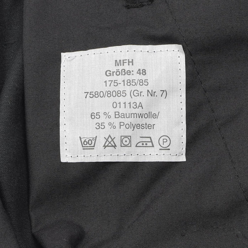 Clothing label on black MFH German Army style cargo pants showing size, fabric composition, and care instructions.