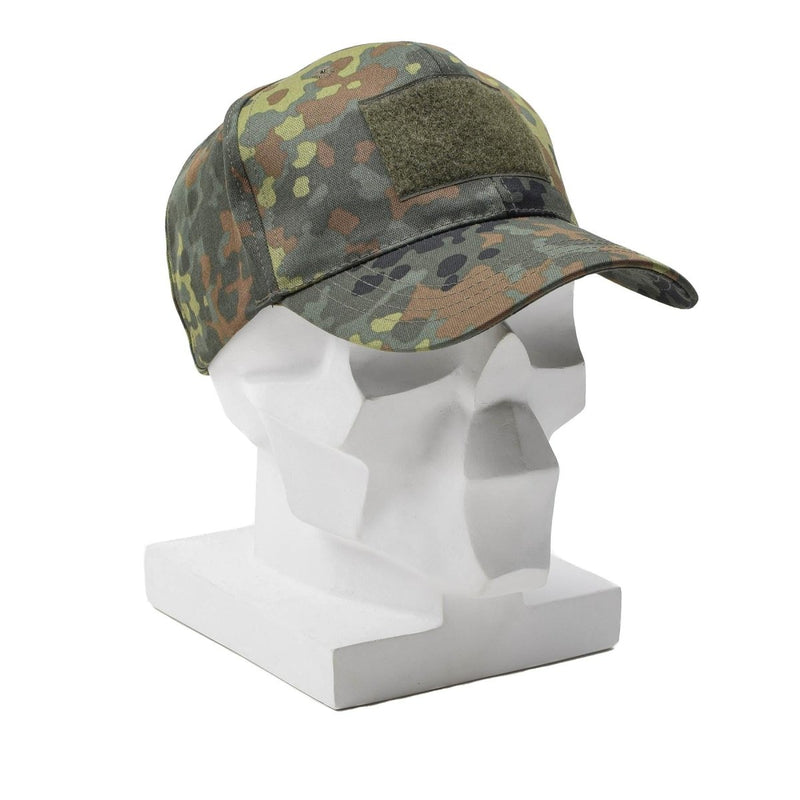 Military flecktarn camouflage baseball cap with peaked visor and adjustable strap on a white mannequin head.