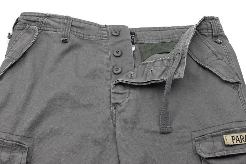 Close-up of Mil-Tec military-style gray cargo shorts with button fly, belt loops, and multiple pockets visible.