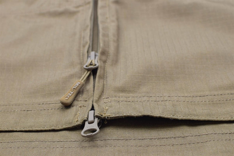 Close-up of Mil-Tec coyote brown ripstop fabric jacket zipper with branded pull tabs and durable stitching detail