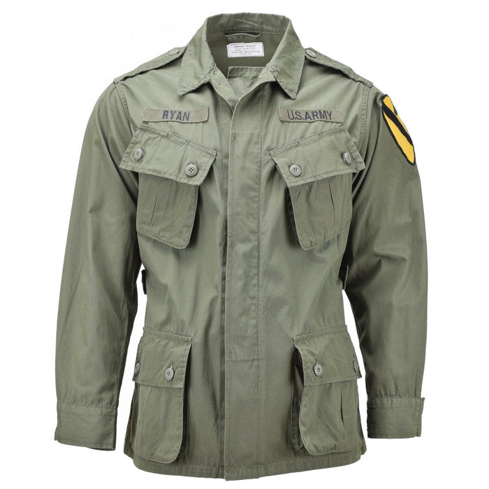 Veste jungle M64 de style vietnamien de l'armée américaine Mil-Tec en olive terne avec plusieurs poches et patchs militaires.