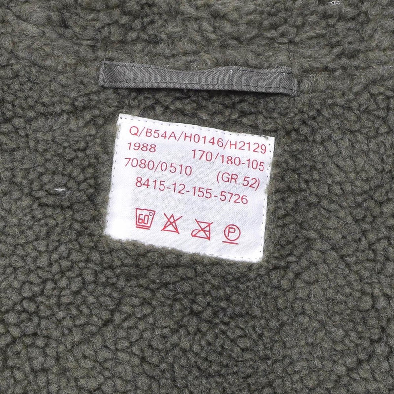 Close-up of olive green faux fur lining with care label inside MIL-TEC German military style parka jacket.