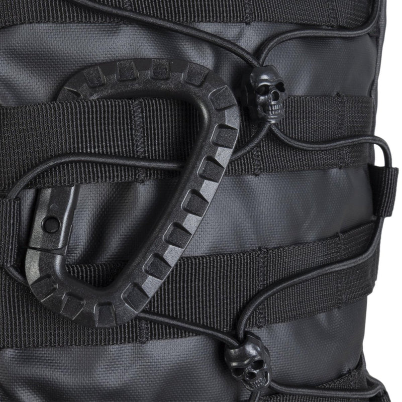 Close-up of black MIL-TEC U.S. Assault tactical backpack showing straps, bungee cords, and skull-shaped cord locks