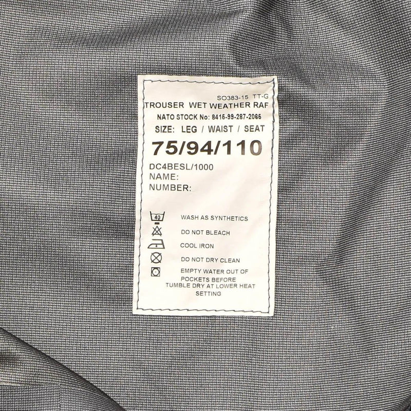 Close-up of a label on waterproof British Royal Air Force wet weather trousers showing size and care instructions.
