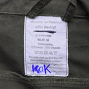 Close-up of the care label on an original Dutch Army Olive OD overall jumpsuit showing fabric blend and washing instructions