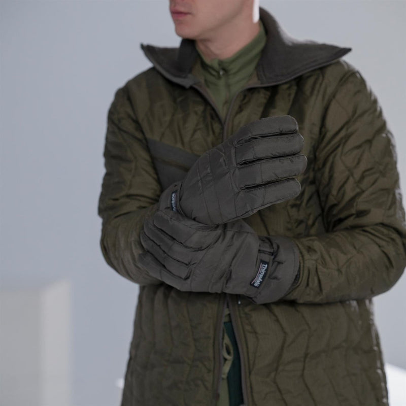 Man wearing an original German army quilted field jacket parka with black insulated gloves winter military style