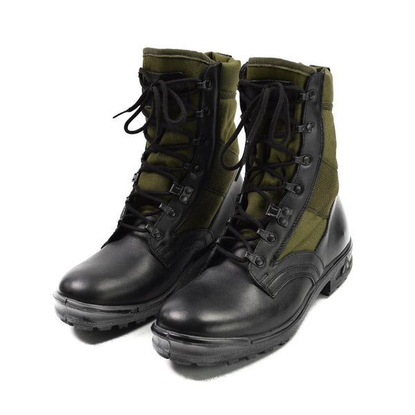 Pair of black and olive green German army tropical boots with laces and side zippers on white background