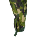 Close-up of Swedish Army M90 camouflage pants ankle with open zipper and button detail for boot fitting.