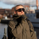 Man wearing SWISS EYE Full frame tactical goggles with UV protection and wide lenses outdoors near water